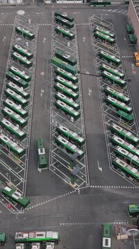 Aerial view of electric buses parked at charging stations in San Donato Milanese, Milan, Italy, illustrating modern public transport and clean energy infrastructure.