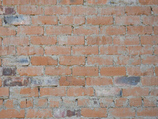 Fototapeta premium Old weathered yellow and red brick wall background with irregular masonry texture