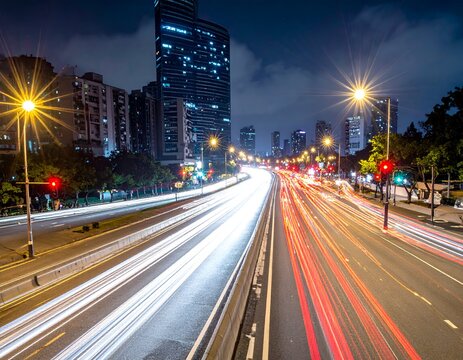 Long exposure shot of a city highway at night, showcasing car light trails