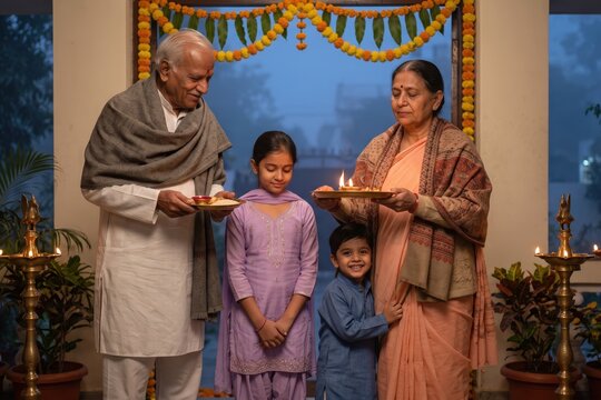 Indian grandparents blessing grandchildren - Diwali aarti at a decorated home doorway.
