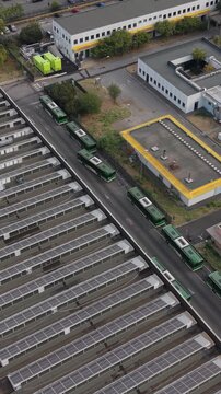 Aerial view of a green electric bus arriving at a charging depot in Milan, Italy, highlighting electric public transport, EV infrastructure and sustainable mobility.