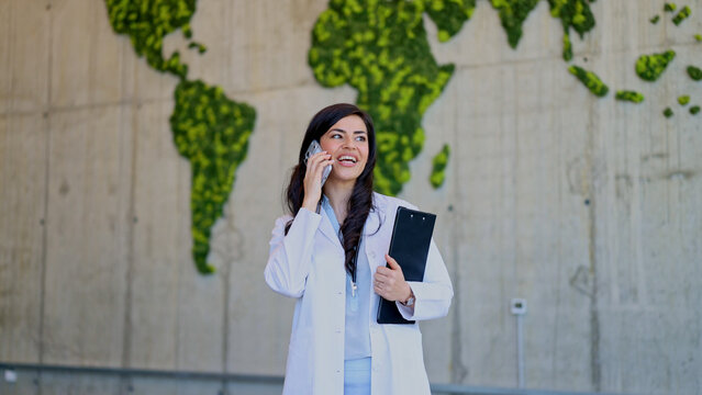 Female doctor talking on phone in front of world map
