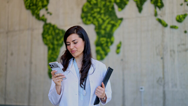 Doctor using smartphone with world map background