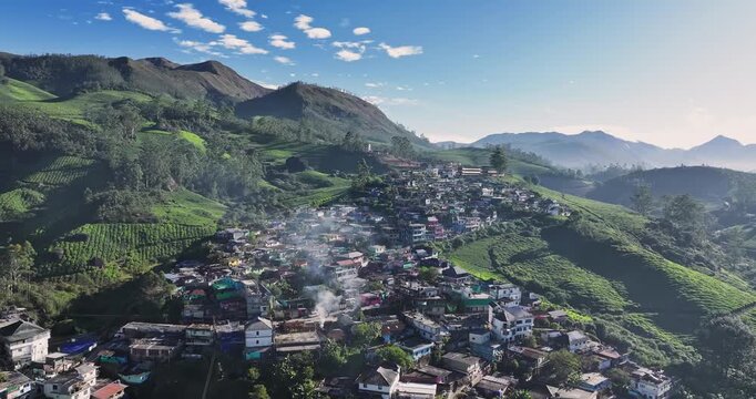 Aerial view of the lush green tea plantations of Munnar, Kerala, covering rolling hills under a bright blue sky with scattered clouds, the scenic beauty of this popular hill station in South India.