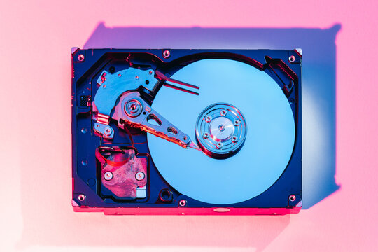 opened computer hard disk drive HDD internal components focusing on plattered disk and actuator read write head arm as a conceptual metaphor for cyber security big data cloud computing infrastructure 