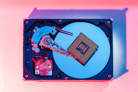processing unit CPU microprocessor chip placed on opened computer hard disk drive HDD components as a conceptual metaphor for AI hardware semiconductor technology data storage infrastructure and cyber
