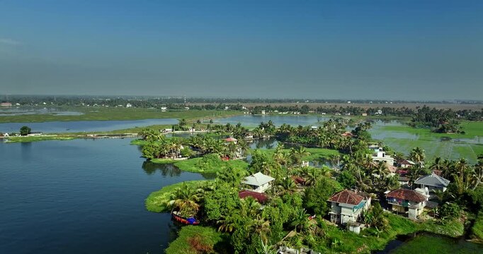 Aerial view of the Alleppey backwaters in Kerala, featuring lush green islands,  village houses, and calm waterways, showcasing the scenic beauty of this popular tourist destination in South India.