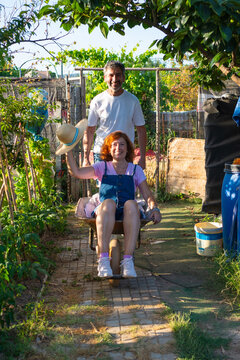 Farmers having fun with wheelbarrow in garden