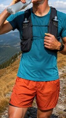 Naklejka premium Male Trail Runner Drinking from Soft Flask on Mountain Trail