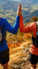 Fototapeta premium Two Trail Runners High Five on Autumn Mountain Trail