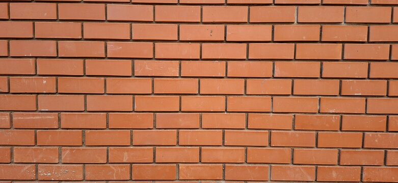 Red brick wall background texture, horizontal running bond masonry pattern, construction material and architecture concept, full frame view
