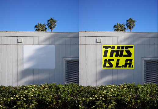 Mockup of A blank billboard sits on a wall in Los Angeles. Green plants and palm trees are in view under a clear blue sky.