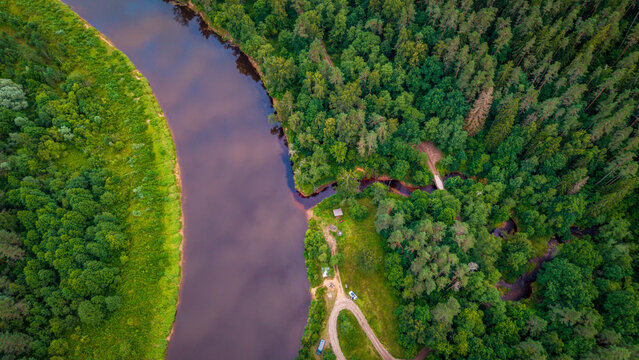aerial perspective looking down at a bend of Gauja River and green tree canopy in Gauja National Park, Latvia