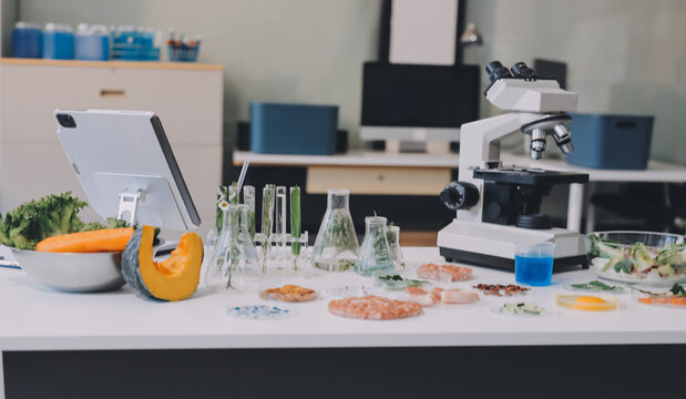Scientists in lab coats work with plants in a modern lab, focusing on research and experimentation under bright, sterile conditions.