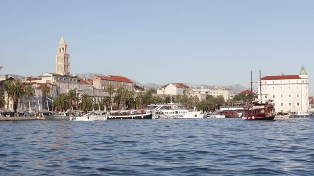 Split, Croatia - August 02, 2025: Largest port in Adriatic coast is located in Split. Private boats and yachts sway on waves, pedestrian tourists walk along embankment