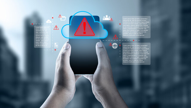 Hands holding a smartphone showing a cloud storage security warning and cyber threat digital graphics over a blurred city background. Cloud computing network data concept