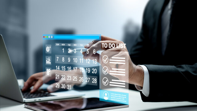 Businessman using a laptop while interacting with a futuristic holographic calendar and digital to-do list interface. Management concept