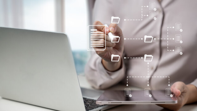 Professional businesswoman organizing digital files and documents in virtual folders using a tablet and laptop. Management concept
