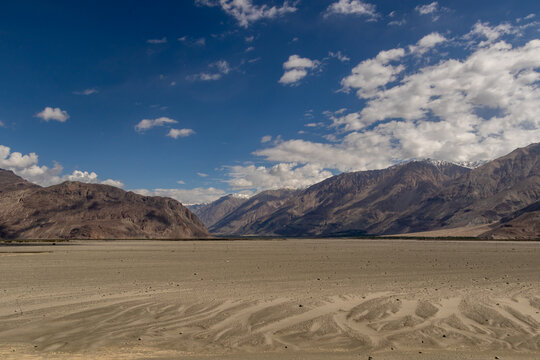 Desert valley with mountains under blue sky