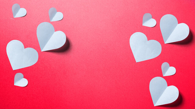 White paper hearts on a textured red background with copy space in the center, perfect for Valentine's Day. Happy Sweetest Day Concept
