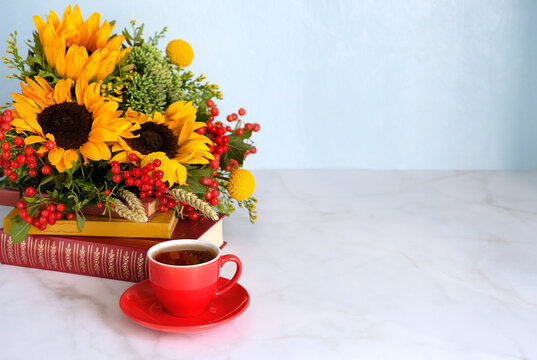 composition with cup of tea, beautiful bouquet with sunflowers and learning books on table. symbol of fall time. Back to school, beginning of the school year, Knowledge Day, 1 September. copy space
