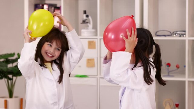 Young Students in Lab Coats Performing Static Electricity Balloon Experiment