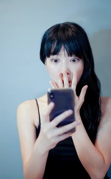 スマホ画面を見てショックを受ける女性 驚き ネットニュース Web広告用背景素材