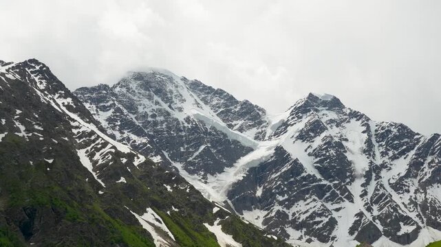 Mountain landscape with blue sky and floating clouds on a sunny day. Mountain landscape with snow-capped mountains and rocky slopes Elbrus

