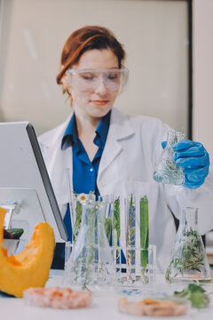 Scientists in lab coats work with plants in a modern lab, focusing on research and experimentation under bright, sterile conditions.