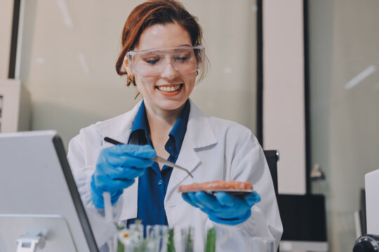 Scientists in lab coats work with plants in a modern lab, focusing on research and experimentation under bright, sterile conditions.