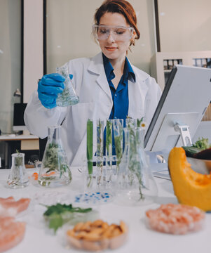 Scientists in lab coats work with plants in a modern lab, focusing on research and experimentation under bright, sterile conditions.
