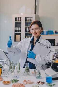 Scientists in lab coats work with plants in a modern lab, focusing on research and experimentation under bright, sterile conditions.