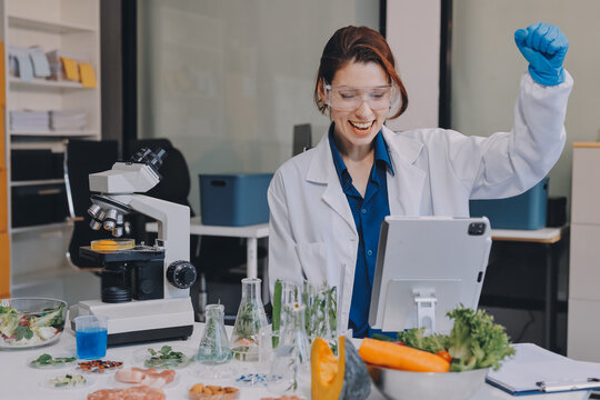 Scientists in lab coats work with plants in a modern lab, focusing on research and experimentation under bright, sterile conditions.