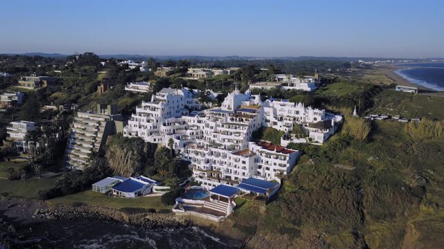 Aerial view of the iconic white sculptural architecture of Casapueblo perched on the rocky cliffs overlooking the Atlantic Ocean in Punta Ballena, Departamento de Maldonado, Uruguay.