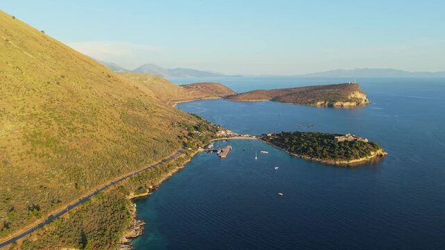 Aerial view of the historic fortress on the peninsula surrounded by clear blue water and rugged hills in Porto Palermo, Qarku i Vlores, Albania.