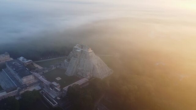 Aerial view of Uxmal pyramid in sunrise fog.