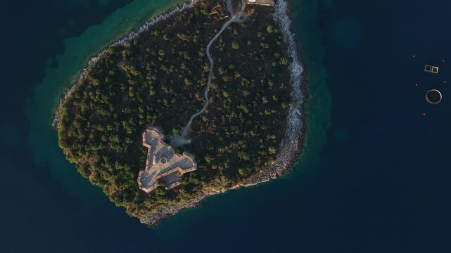Aerial view of the historic triangular fortress on the island of Porto Palermo surrounded by deep blue sea in Porto Palermo, Qarku i Vlores, Albania.