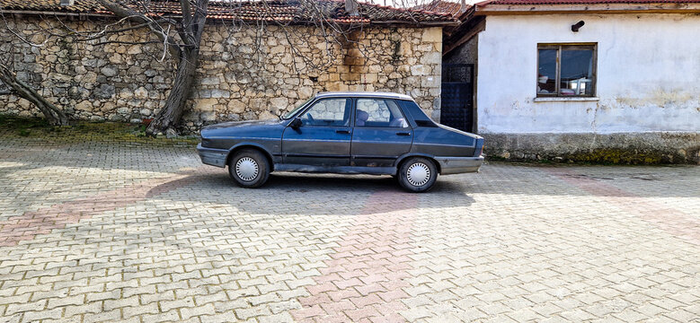 Classic blue Renault 12 Toros vintage car from the 1980s parked in front of a historic stone wall, rural village scene and car in Kirklareli, Thrace, Turkey 28.03.2025