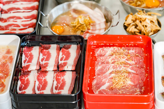Thai Pork BBQ Buffet (Mu Kratha) &ndash; Delicious grilled sliced pork and fresh vegetables on a traditional dome skillet. Perfect for street food, Asian cuisine, and dining background graphics.