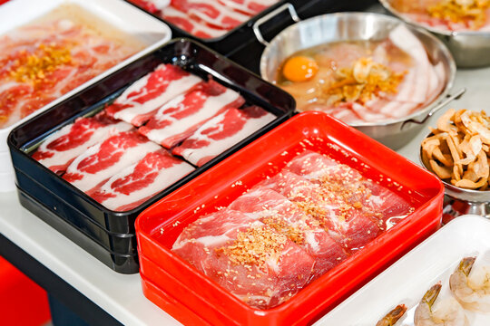 Thai Pork BBQ Buffet (Mu Kratha) &ndash; Delicious grilled sliced pork and fresh vegetables on a traditional dome skillet. Perfect for street food, Asian cuisine, and dining background graphics.