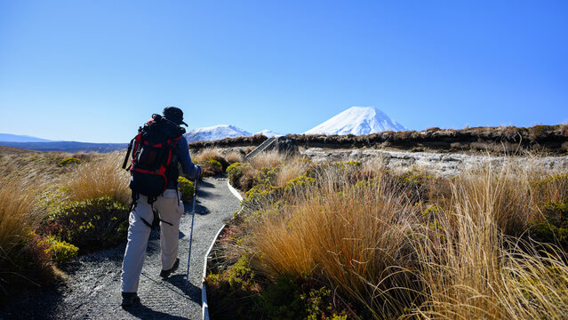Hiking Tama Lake Tracks in winter. Snow-capped Mount Ngauruhoe in the distance. Tongariro National Park. New Zealand.