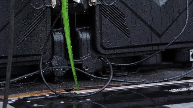 Close-up wet black electrical panel with green cable dangling into puddle. Rain droplets create critical short circuit risk, electrical fire hazard, dangerous outdoor safety scene vertical 4k shot