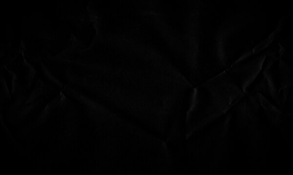 Dark black crumpled paper texture background with crease lines and subtle shadows for design Background