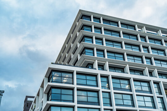 View of the modern glass and concrete facade of the King's Cross St. Pancras building under a cloudy sky in London, England, United Kingdom.
