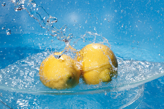 Water splashing on fresh lemons