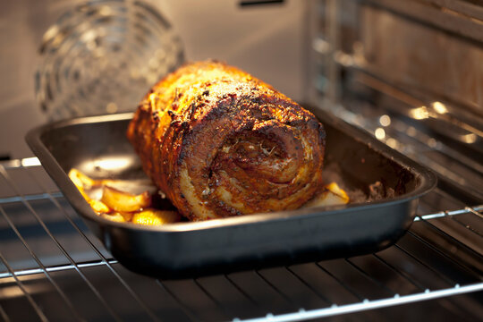 A rolled roast pork bakes inside an electric oven