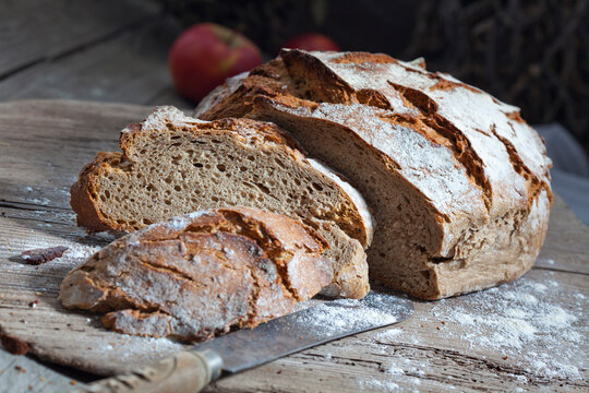 Crusty bread and old bread knife on chopping board