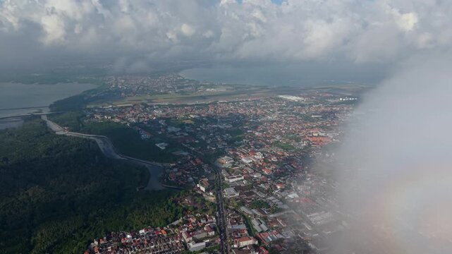 Aerial view of the Statue of Dewa Ruci surrounded by urban development, roads, and lush greenery in Kecamatan Kuta, Bali, Indonesia.