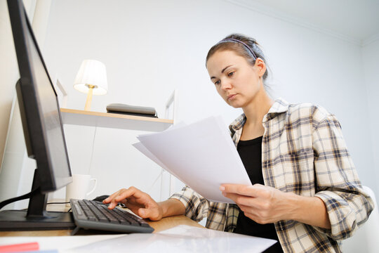 Reviewing paper documents and entering information on a computer at home, handling paperwork, data entry and administrative office tasks.