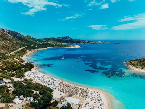 Drone captures an aerial view of a turquoise sea and sandy beach
